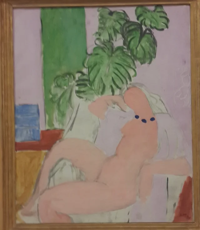 Nu dans un fauteuil, plante verte