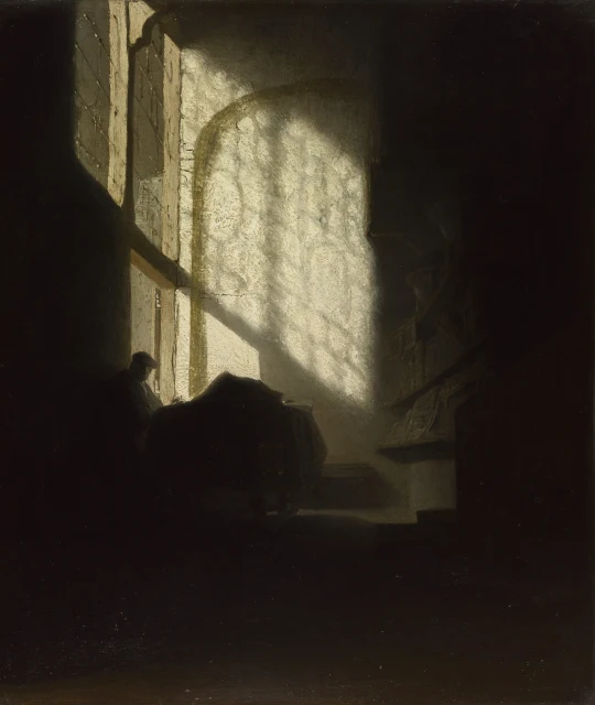 A Man seated reading at a Table in a Lofty Room